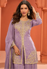 Load image into Gallery viewer, Woman wearing a purple embroidered traditional outfit with gold details against an orange background