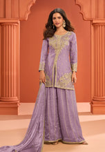 Load image into Gallery viewer, Woman wearing a purple embroidered traditional outfit against an orange architectural background