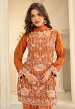 Load image into Gallery viewer, Woman wearing an orange embroidered traditional outfit with a neutral background