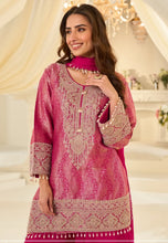 Load image into Gallery viewer, Woman wearing a pink embroidered traditional outfit in an elegant indoor setting.
