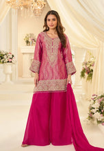 Load image into Gallery viewer, Woman in a pink traditional outfit with intricate patterns in a decorated indoor setting.