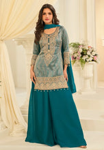 Load image into Gallery viewer, Woman wearing a teal and gold traditional outfit in a decorated room.