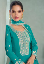 Load image into Gallery viewer, Woman wearing a teal embroidered traditional outfit 
