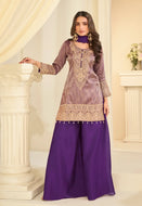Woman wearing a traditional outfit with a purple top and skirt in an elegant interior setting.