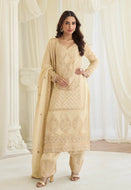 Model wearing a cream Simar silk Pakistani style embroidered kurta set with beadwork, matching palazzo pants, and a coordinated dupatta.