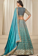 Load image into Gallery viewer, Woman wearing a blue and green traditional outfit with a matching dupatta.

